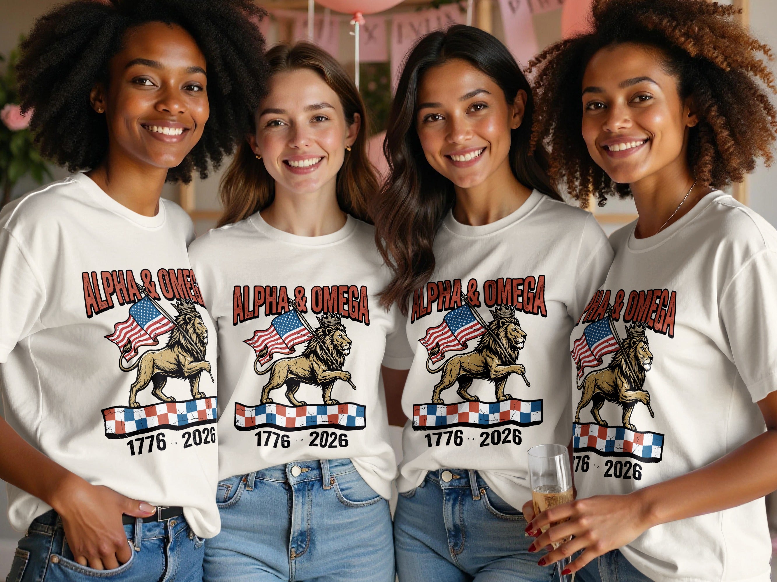 Four women wear white t-shirts with a lion, flags, and "ALPHA & OMEGA 1776 2026".