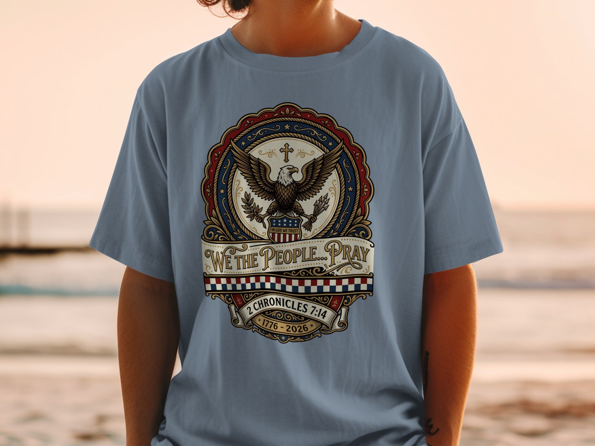 Blue t-shirt with eagle emblem, "We the People...Pray," and dates 1776-2026.