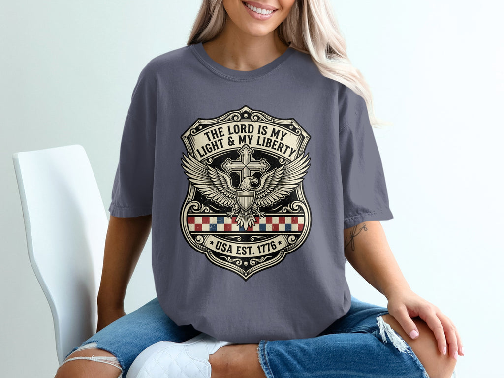 Dark grey t-shirt with shield design, cross, wings, and text.