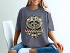 Dark grey t-shirt with shield design, cross, wings, and text.