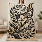 Beige blanket with ornate gold and black floral design and a bird.