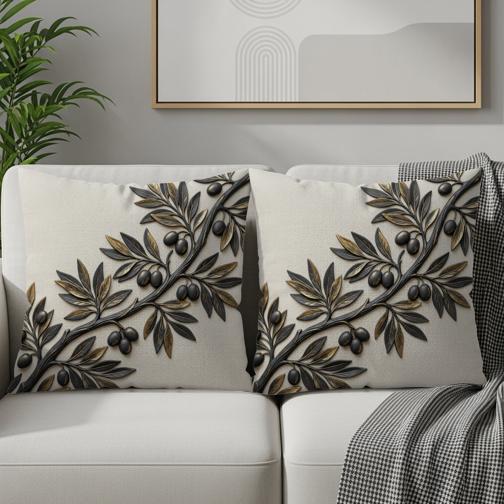Two cream decorative pillows with embossed olive branch design on a sofa.