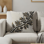 Cream decorative pillow with raised gold and black olive branch design.