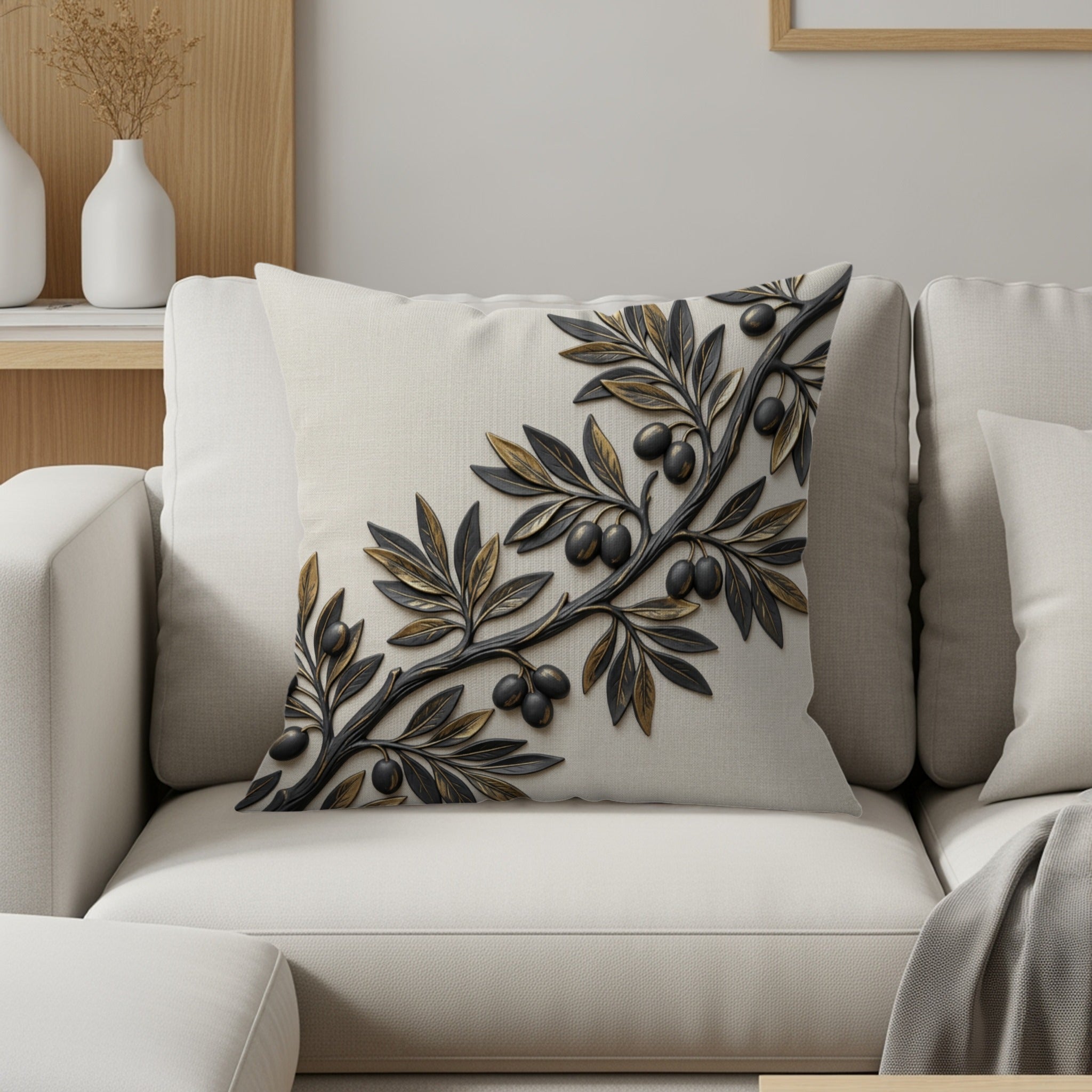Cream decorative pillow with raised gold and black olive branch design.