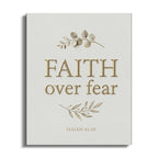 Canvas art with "FAITH over fear" and "ISAIAH 41:10" text, adorned with leaves.