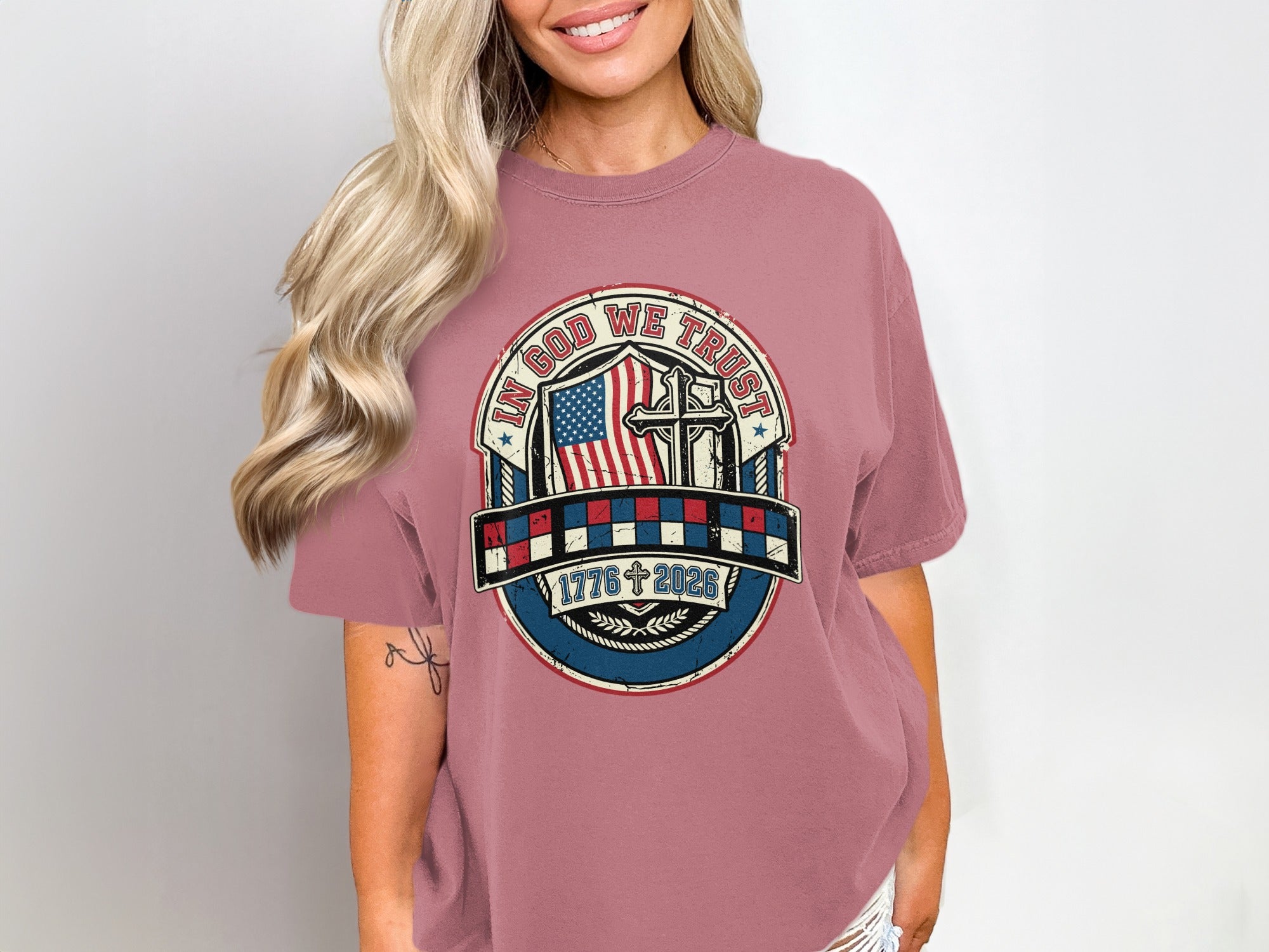 T-shirt with "In God We Trust" emblem, American flag, cross, and dates.