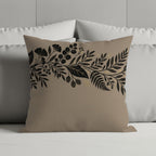 Tan pillow with black and gold botanical floral border design.