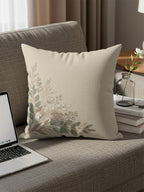 Light beige pillow with delicate floral vine pattern on a sofa.