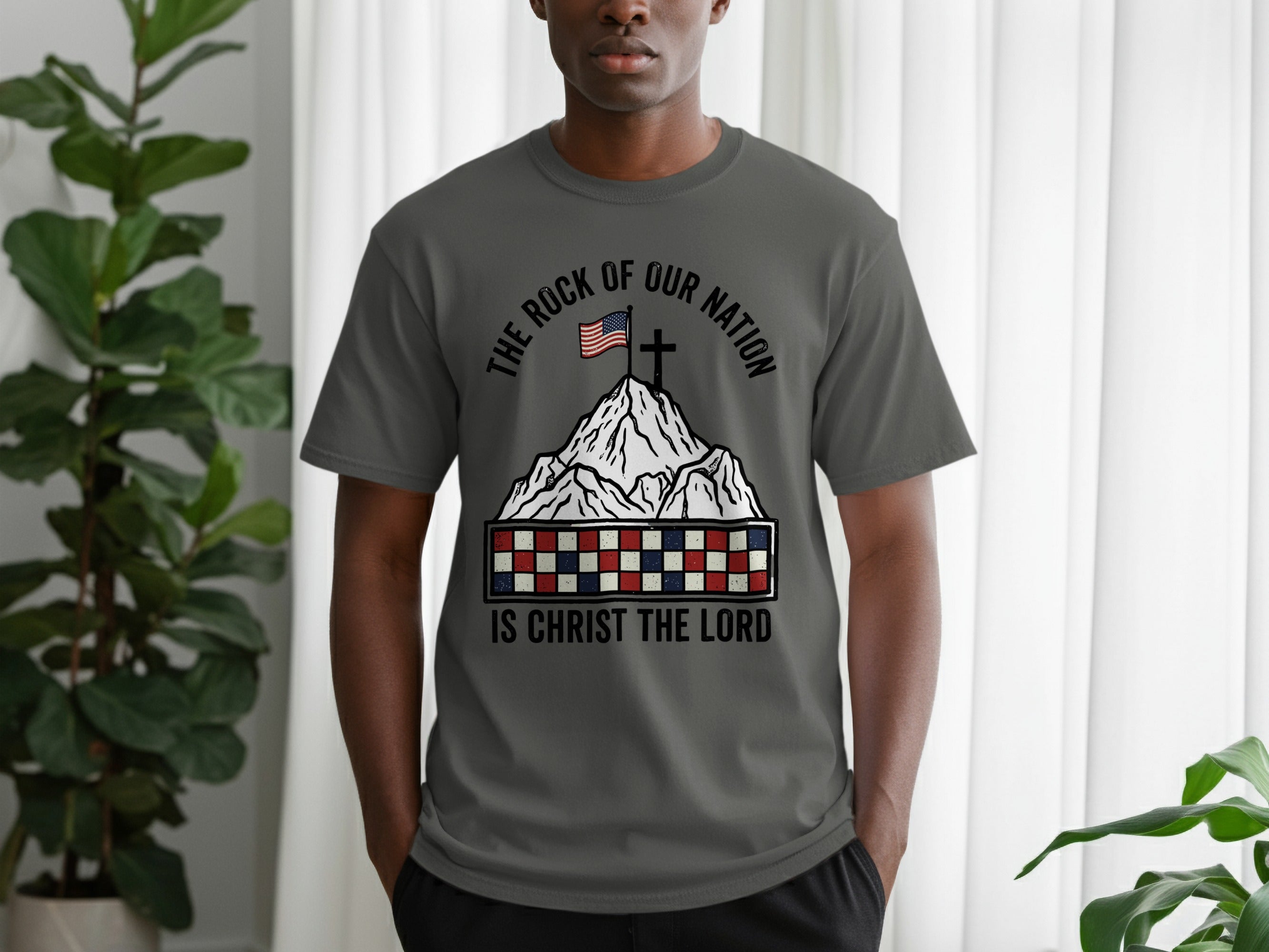 Gray t-shirt with mountain, flag, and text "The Rock of Our Nation Is Christ the Lord".