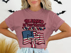 "Blessed is the nation" text with American flag graphic on dusty rose t-shirt.