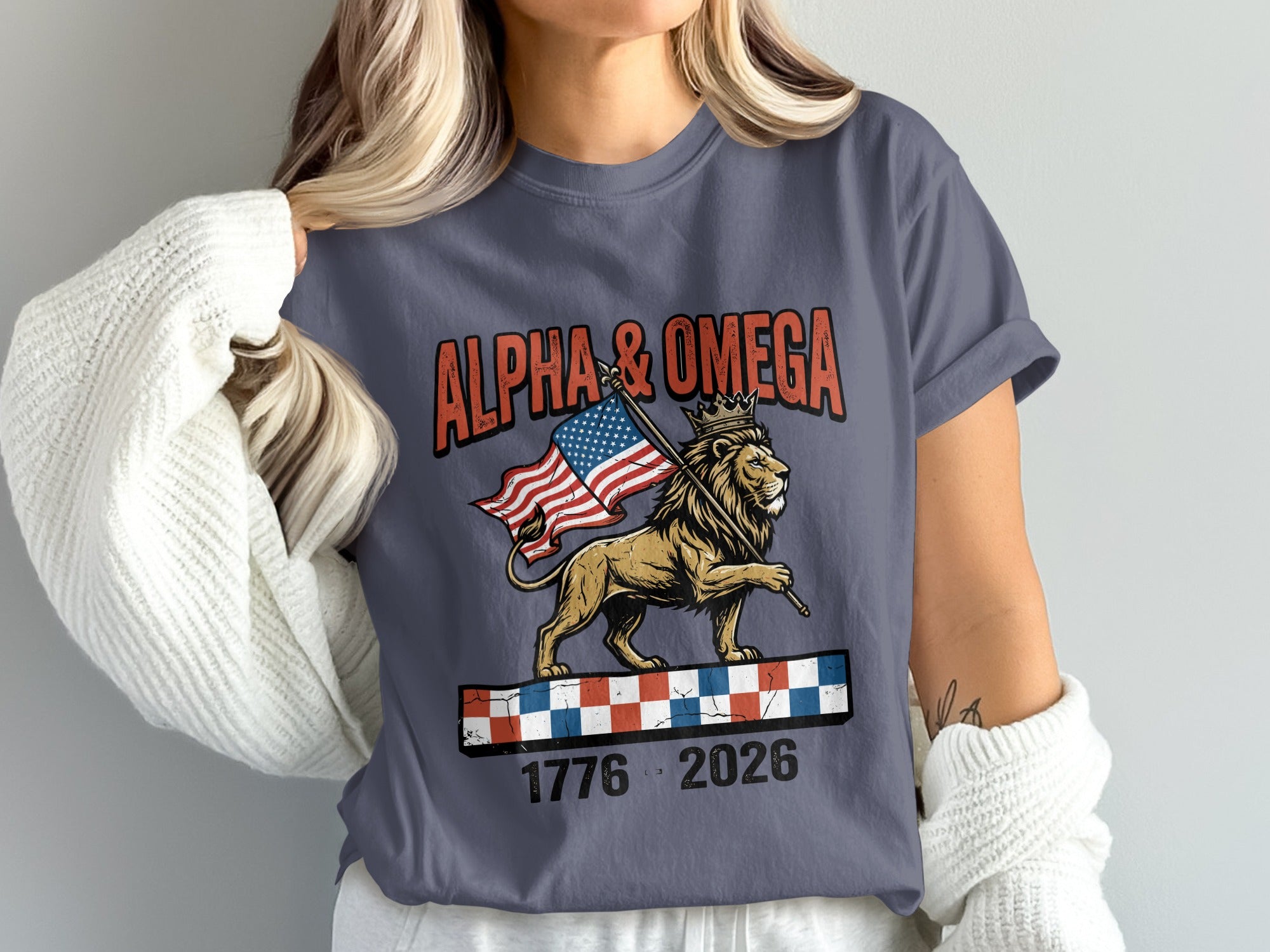 Lion with crown holding American flag, text "ALPHA & OMEGA 1776 2026".