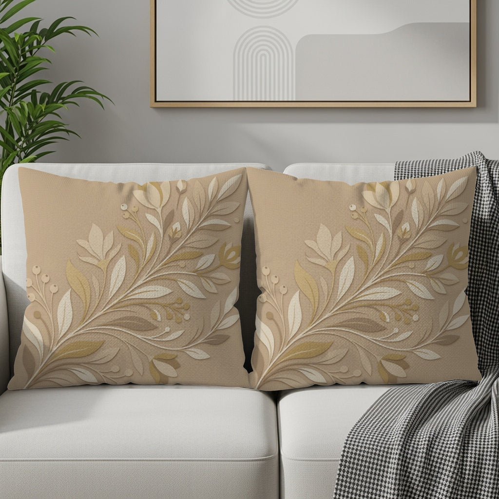 Two beige throw pillows with raised floral patterns rest on a white couch.