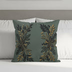 Green throw pillow with gold floral design centered on a bed.