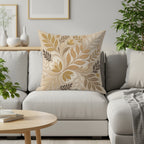 Beige throw pillow with ornate floral pattern on a grey couch.