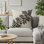 Cushion with a stylized olive branch design on a sofa.