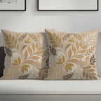 Two throw pillows with a floral leaf pattern on a sofa.