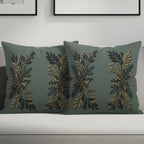 Two sage green throw pillows with gold botanical embroidery.