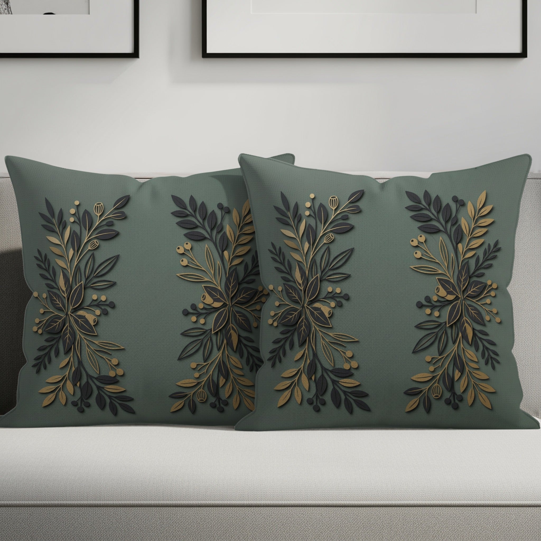 Two sage green throw pillows with gold botanical embroidery.