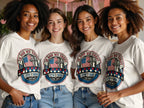 Four women wear matching "In God We Trust" t-shirts with American flag and cross graphic.