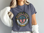 T-shirt with blue and gold emblem featuring a cross and "Rejoice in Hope".