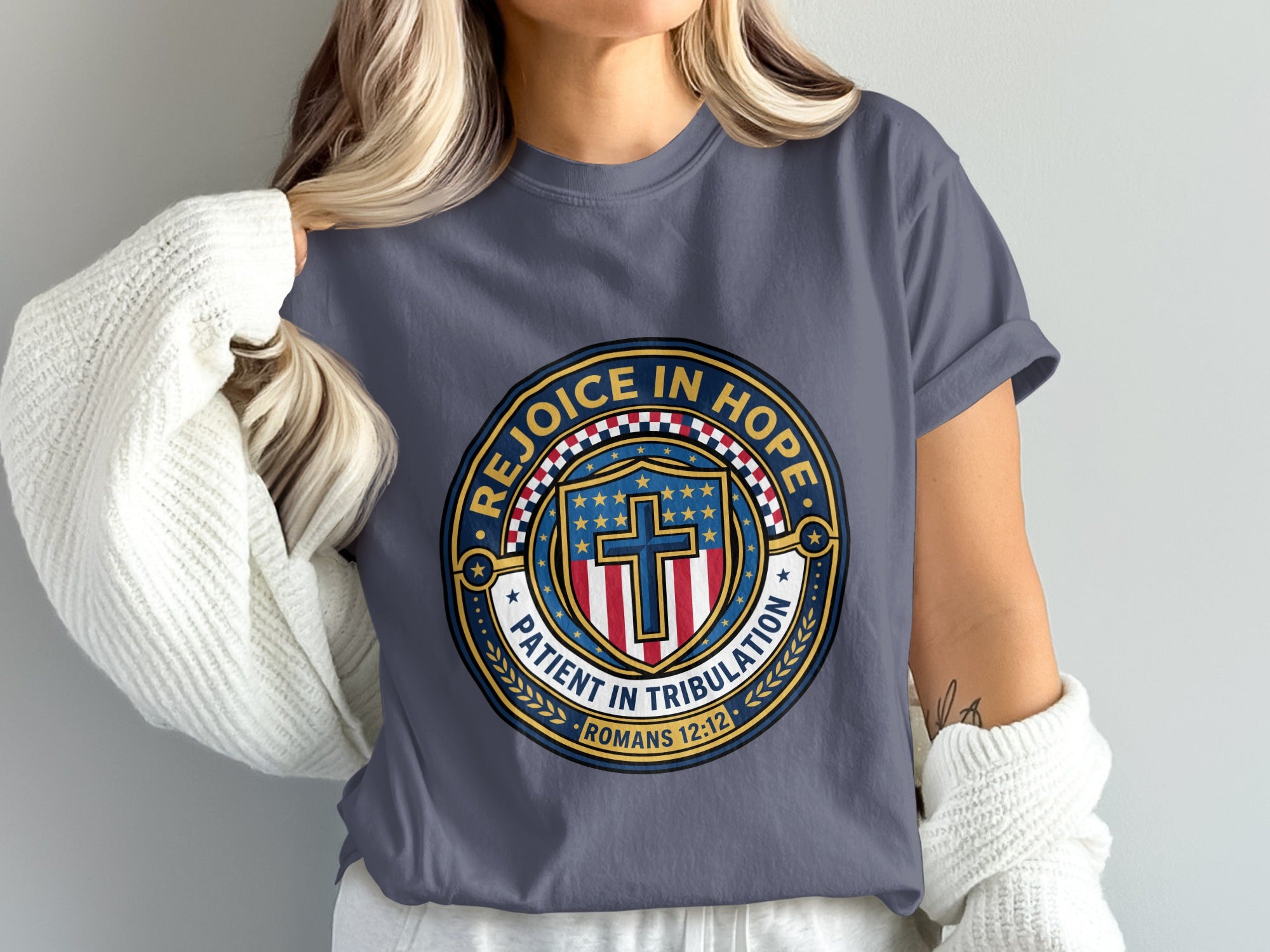 T-shirt with blue and gold emblem featuring a cross and "Rejoice in Hope".