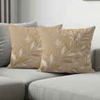 Beige decorative throw pillows with floral embroidery on a gray couch.