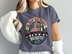 T-shirt with "In God We Trust" emblem featuring American flag and cross.