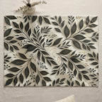 Cream placemat with black leaf and vine pattern, featuring subtle cross and dove symbols.