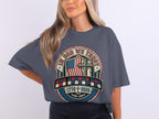 Gray t-shirt with patriotic graphic featuring American flag, cross, and "In God We Trust 1776 2023".