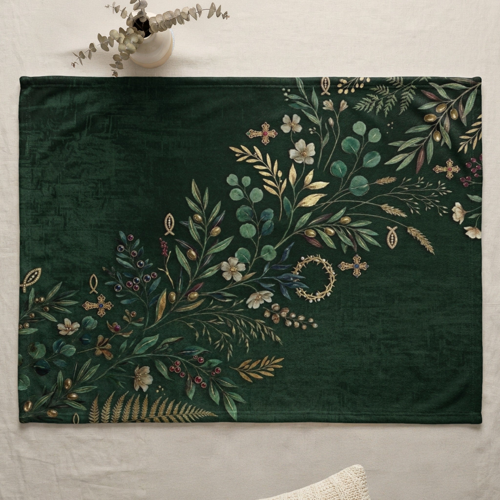 Green fleece throw blanket with botanical and cross designs.