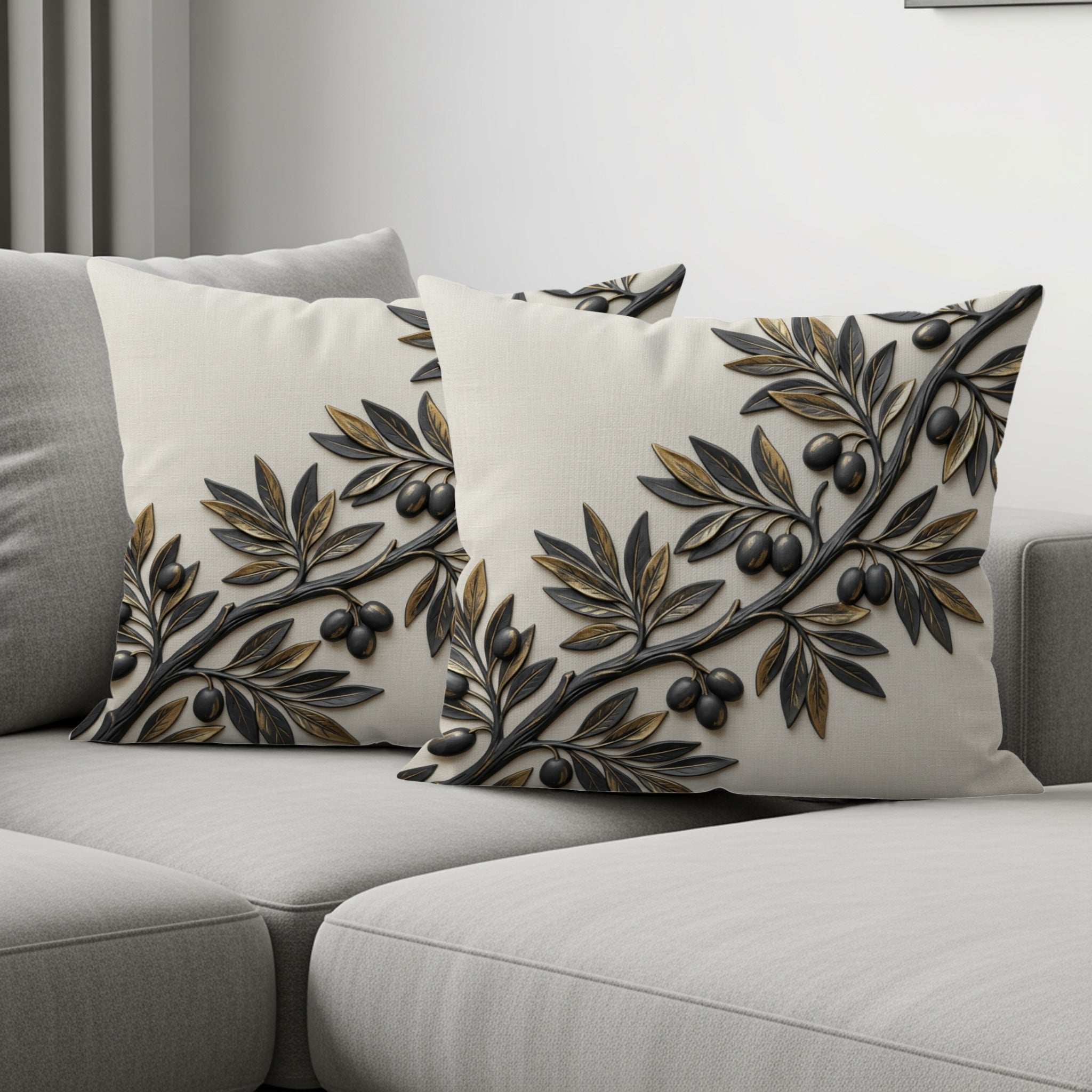 Two cream throw pillows with an embossed olive branch design on a sofa.