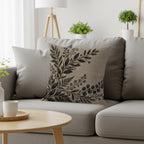 Textured gray pillow with dark botanical design on a light gray sofa.