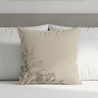 Tan decorative pillow with a delicate floral design on the left.