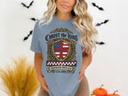 Light blue t-shirt with "Christ the King Sovereign Over USA" shield design.
