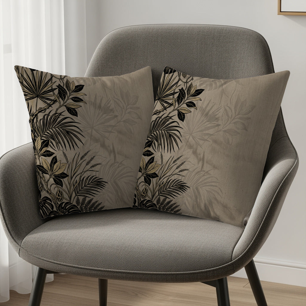 Two decorative throw pillows with tropical leaf patterns on a gray chair.