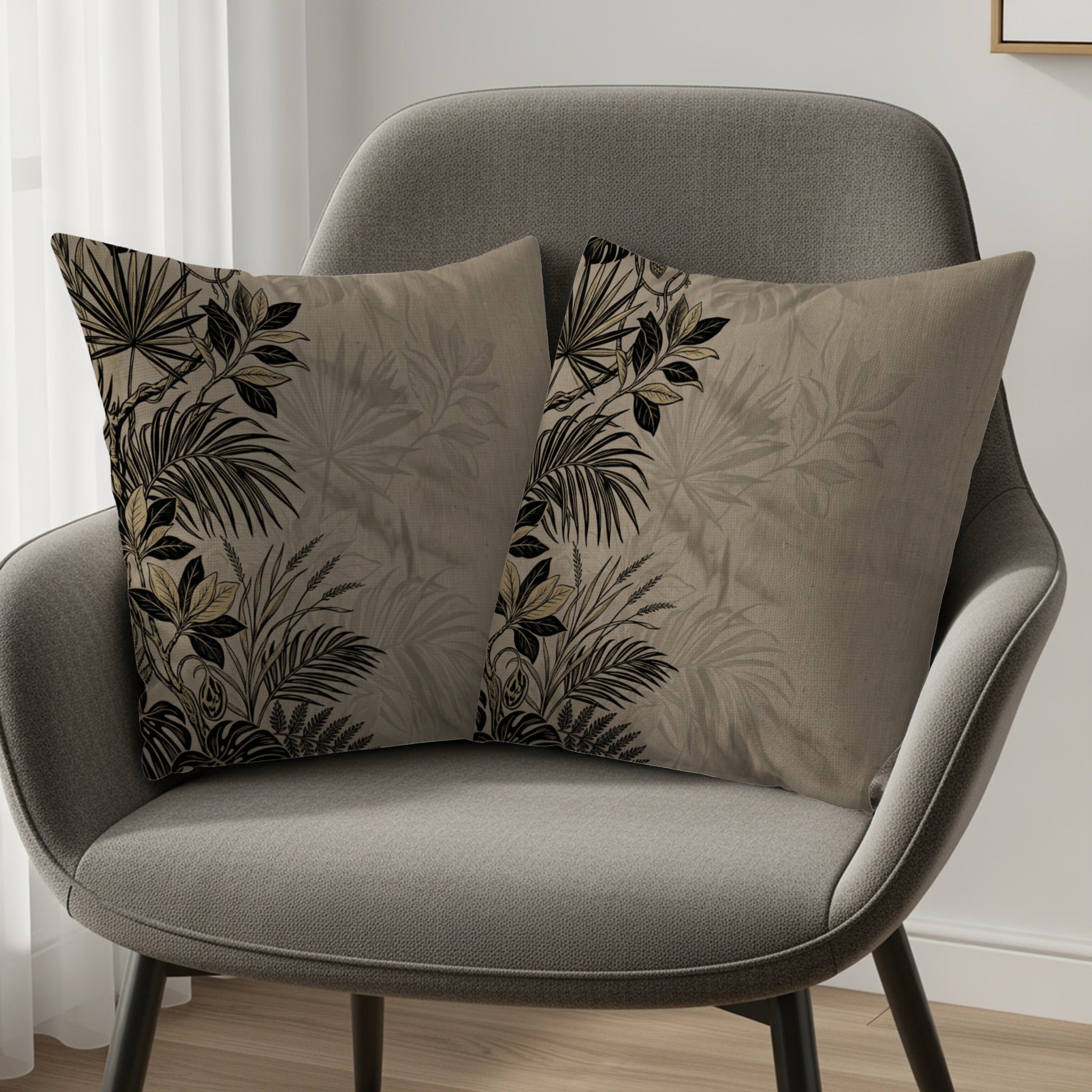 Two decorative throw pillows with tropical leaf patterns on a gray chair.