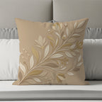 Tan decorative throw pillow with embossed floral vine design on a bed.