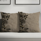 Two throw pillows with botanical print on a couch.