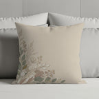 Beige throw pillow with delicate floral design on corner.
