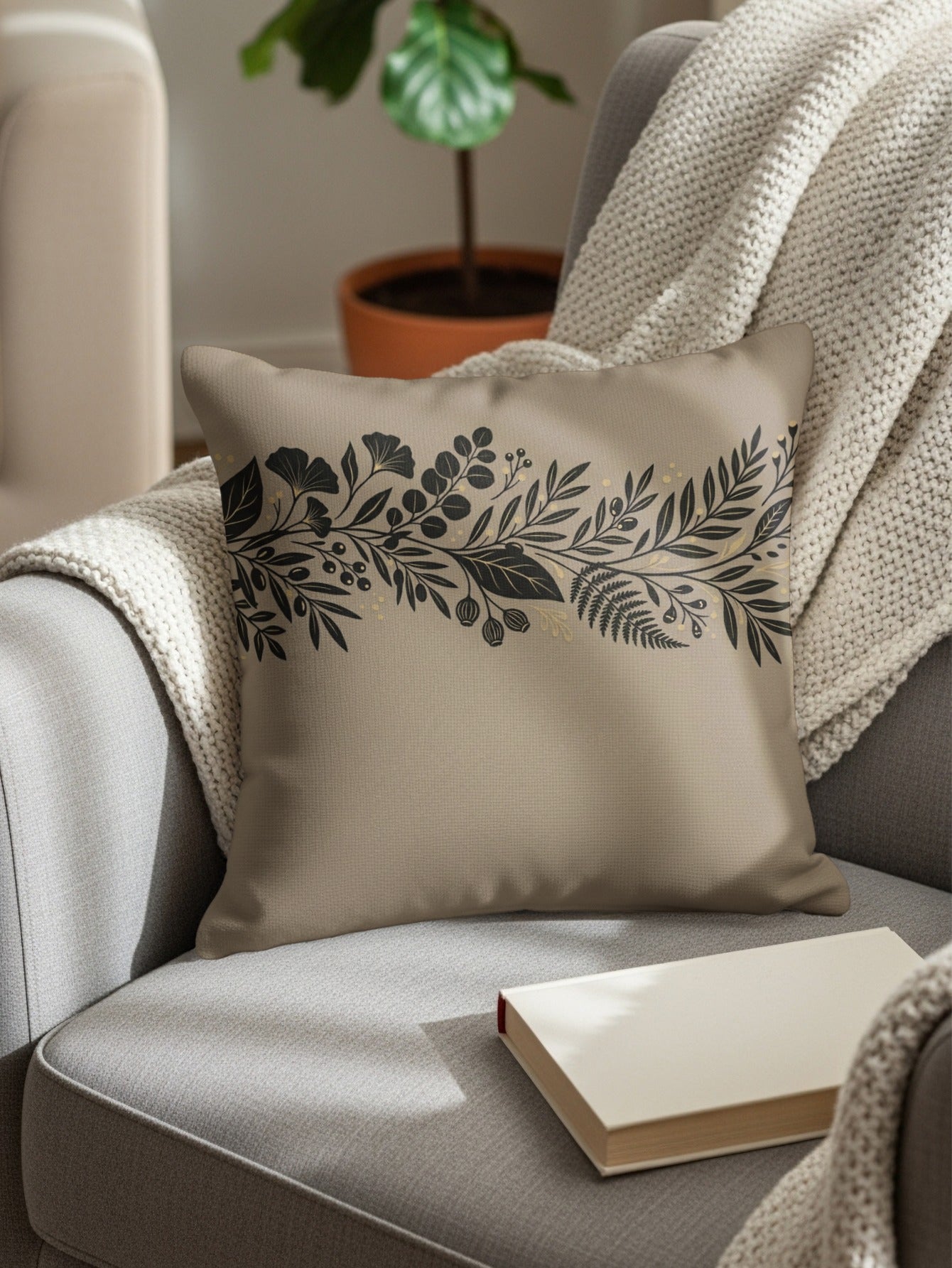 Beige decorative throw pillow with botanical design on armchair.