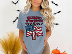 Woman wearing blue t-shirt with American flag and "Blessed is the Nation" text.