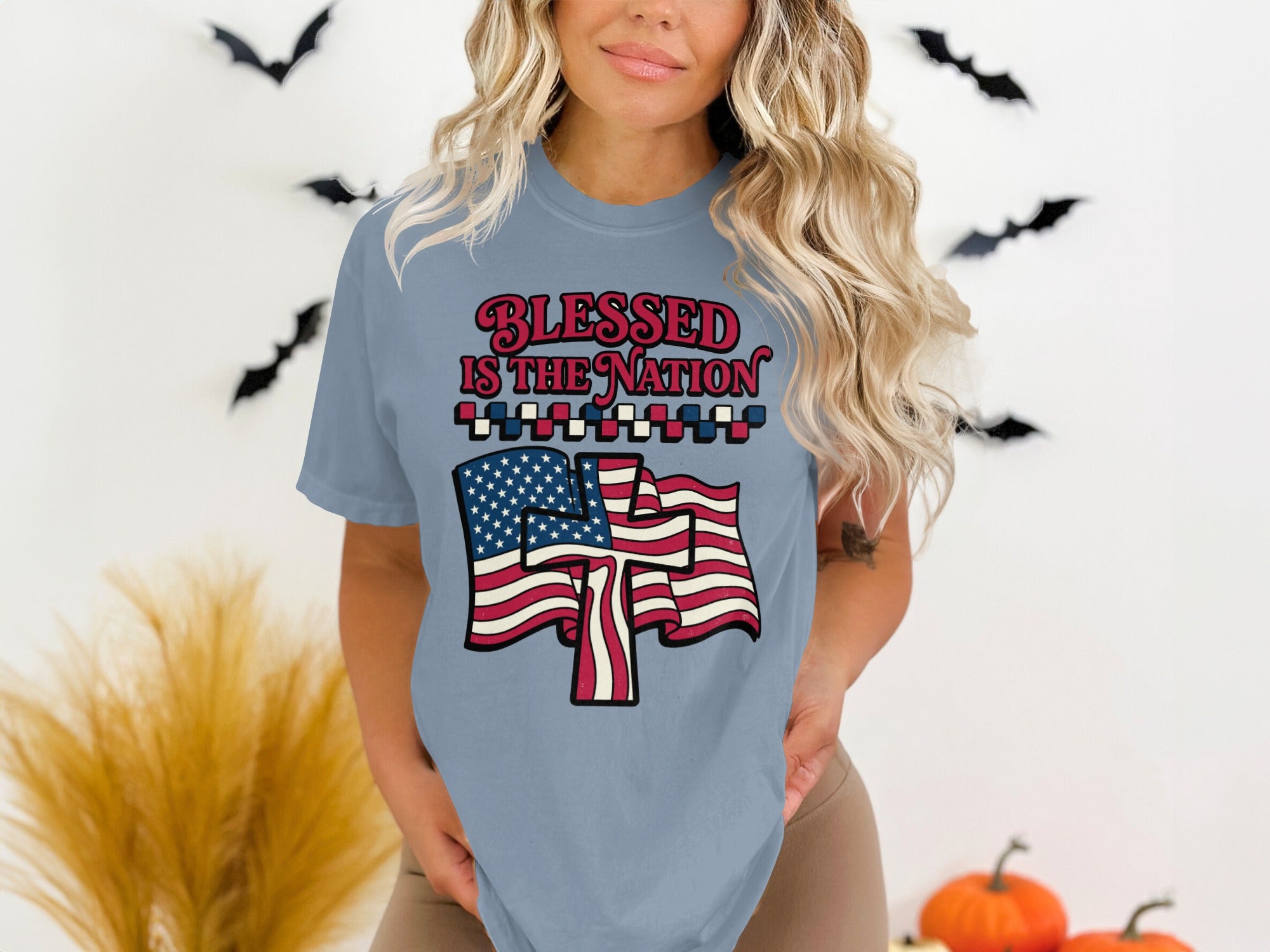 Woman wearing blue t-shirt with American flag and "Blessed is the Nation" text.