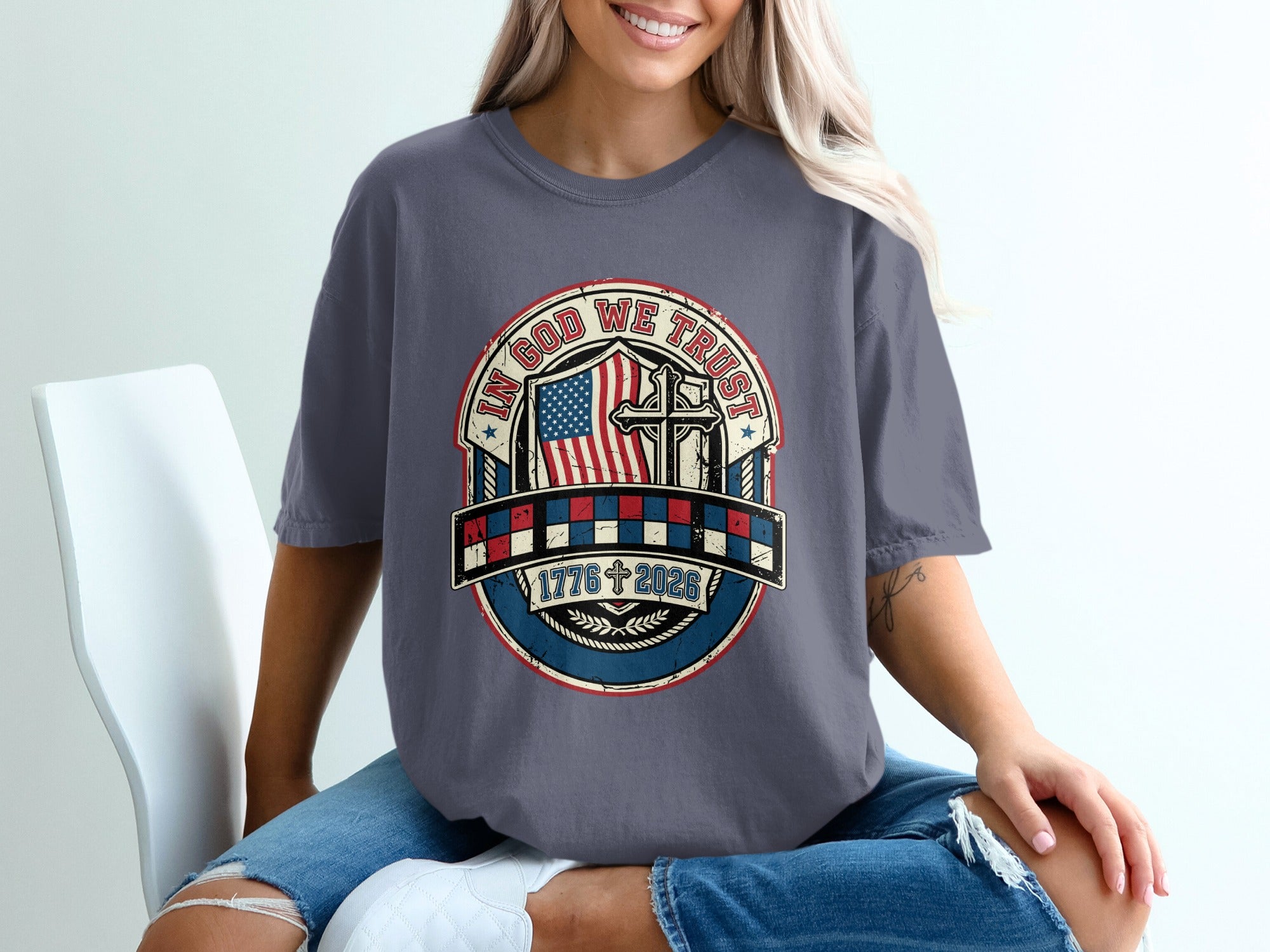 T-shirt with "In God We Trust" emblem featuring American flag and cross.