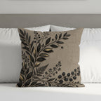 Brown throw pillow with gold and black botanical leaf design on textured fabric.
