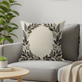 Cream throw pillow with black floral border design.