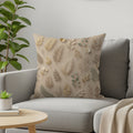 Beige throw pillow with repeating botanical leaf pattern.