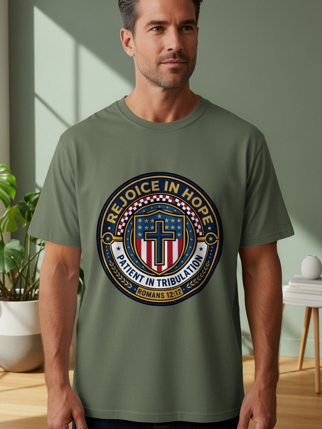 Olive green t-shirt with a circular emblem featuring a cross and "Rejoice in Hope" text.
