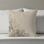 Beige throw pillow with a delicate floral botanical design in the corner.