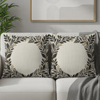 Two square throw pillows with a floral wreath design on a couch.